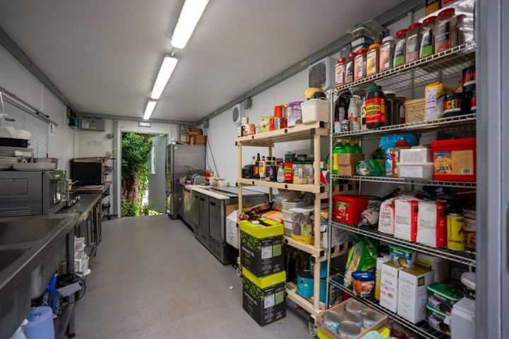 Temporary kitchen featuring undercounter fridges and freezers, storage racking. ovens and other commercial catering equipment